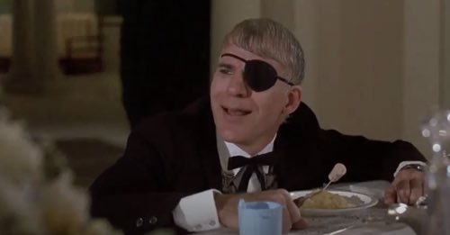 Steve Martin holds a fork with a cork on the end of the tines in the movie My Blue Heaven